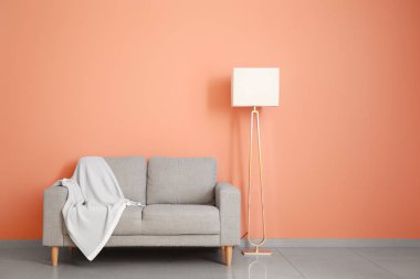 Odanın duvarına lamba asılmış şık bir kanepe.