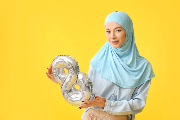 Schöne muslimische Frau mit Luftballon in Form von Figur 8 auf farbigem Hintergrund. Internationaler Frauentag — Stockfoto