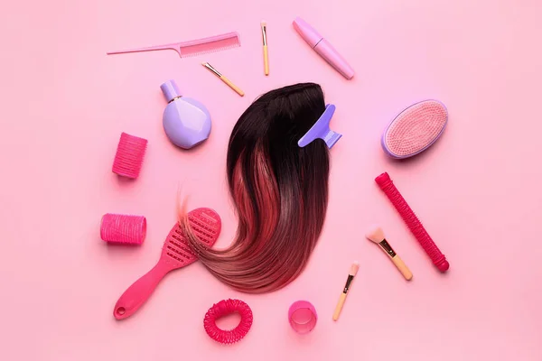 Состав с прядью волос и различными инструментами на цветном фоне — стоковое фото