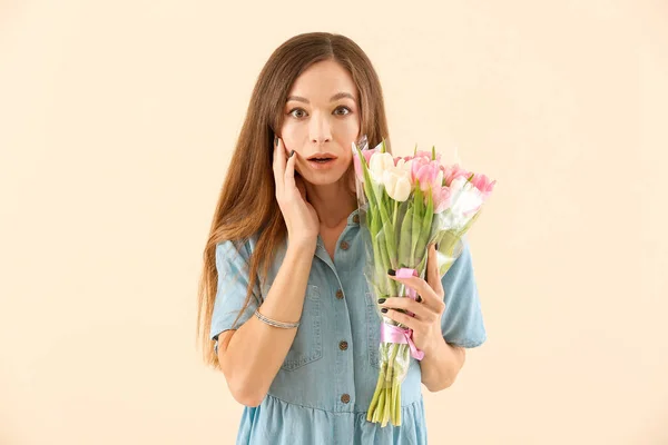 Krásná mladá žena s květinami na barevném pozadí. Mezinárodní oslava Dne žen — Stock fotografie