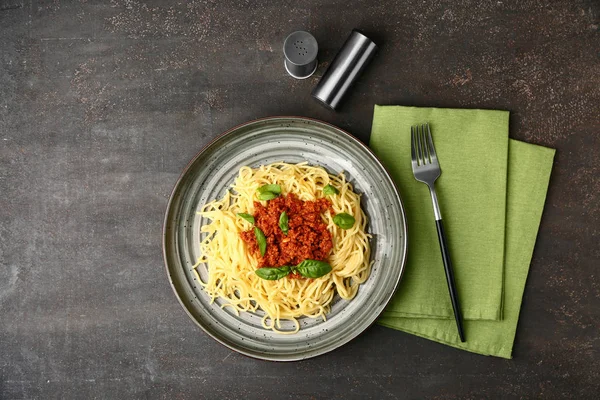 Talerz ze smacznym makaronem bolognese na szarym tle — Zdjęcie stockowe