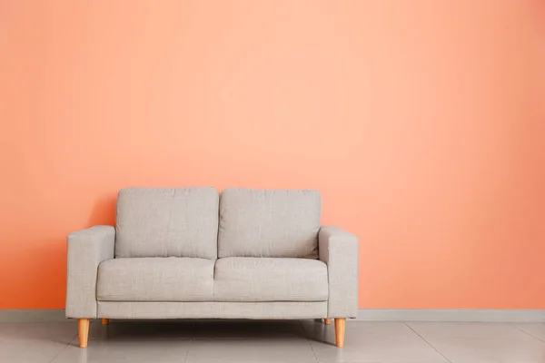 Stylish sofa near color wall in room — Stock Photo, Image