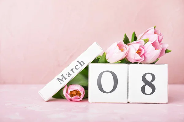 Calendário com data do Dia Internacional da Mulher e flores na mesa — Fotografia de Stock