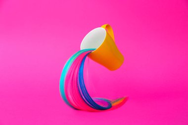 Cup and strand of colorful hair on bright background