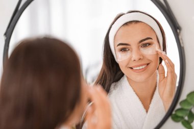 Banyoda göz altı bantları olan güzel genç bir kadın.