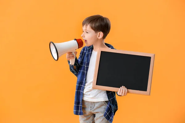 Little schoolboy with chalkboard and megaphone on color background — Stockfoto