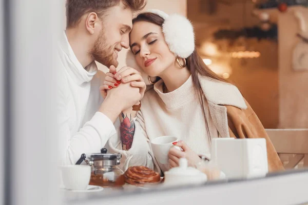 Happy young couple sitting in cafe, view through glass window — Stock Photo, Image