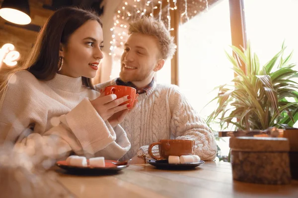 Feliz joven pareja sentada en la cafetería —  Fotos de Stock