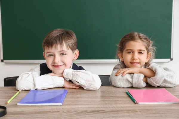 Kleine leerlingen aan het bureau in de klas — Stockfoto