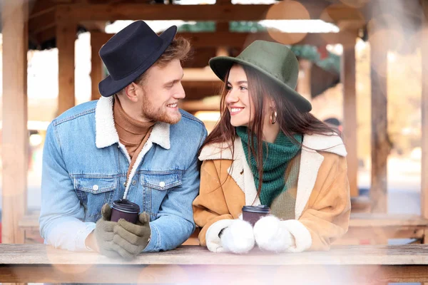 Feliz pareja joven en la feria de Navidad al aire libre —  Fotos de Stock