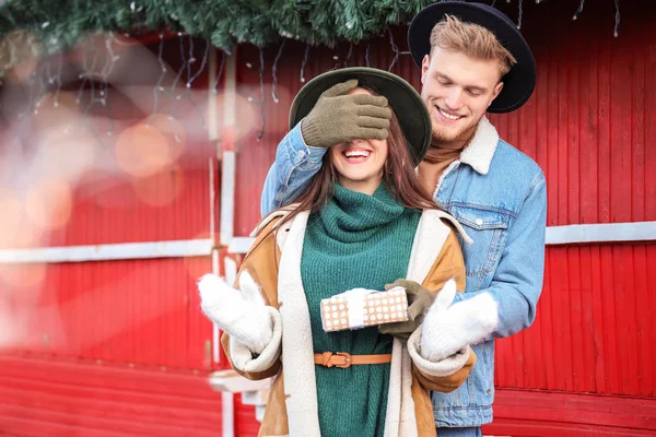 Young man greeting his girlfriend on Christmas outdoors — Stock Photo, Image