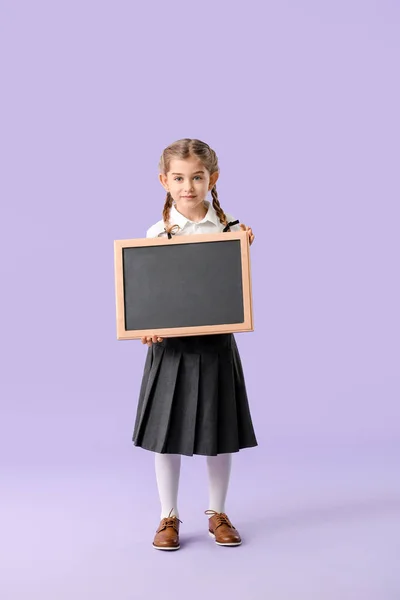 Pequena estudante com quadro-negro no fundo de cor — Fotografia de Stock