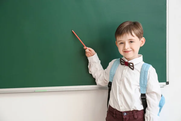 Sınıfta tahtanın yanındaki küçük okul çocuğu. — Stok fotoğraf