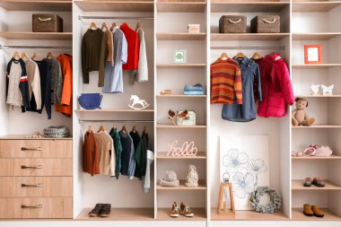 Modern wardrobe with stylish winter clothes and accessories