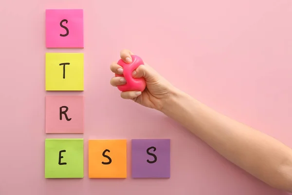 Mano spremitura palla di stress su sfondo di colore — Foto Stock