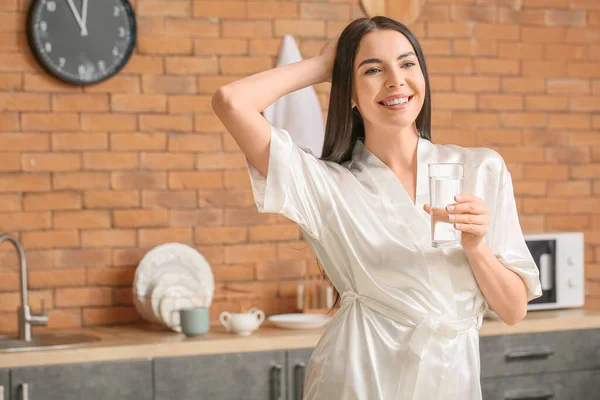 Morning of beautiful young woman with glass of water in kitchen — Stock Photo, Image