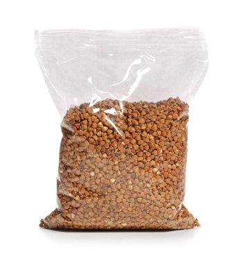 Beyaz zemin üzerinde çiğ karabuğday olan plastik paket