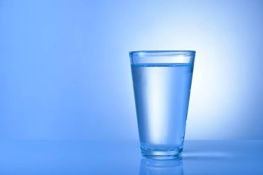 Renkli arka planda bir bardak taze su