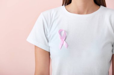 Pembe kurdeleli genç bir kadın, yakın plan. Kanser farkındalığı kavramı