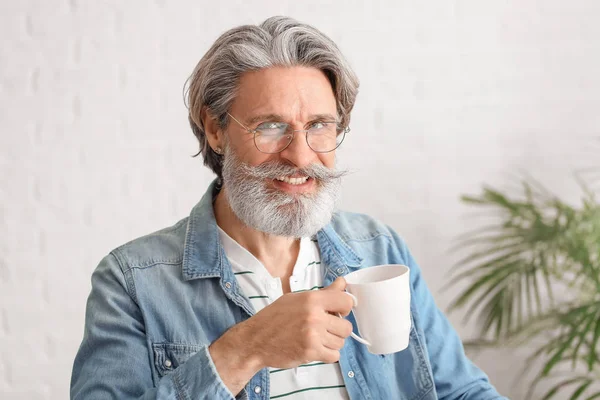 Happy elderly man drinking tea in office — Stock Photo, Image