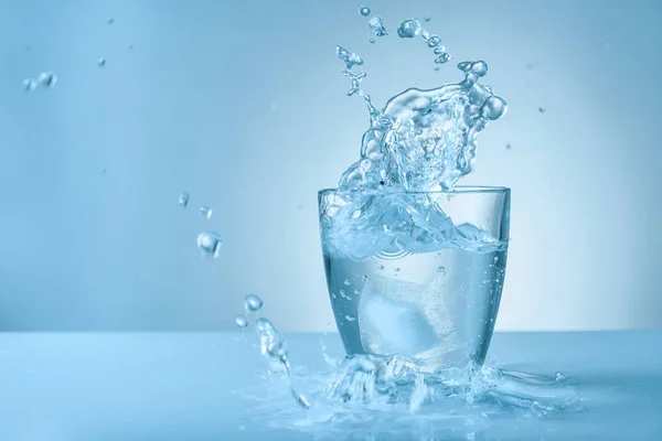 Vaso de agua dulce con salpicadura sobre fondo de color —  Fotos de Stock