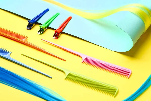 Papier, Haarsträhne, Klemmnadeln und Kämme auf farbigem Hintergrund — Stockfoto