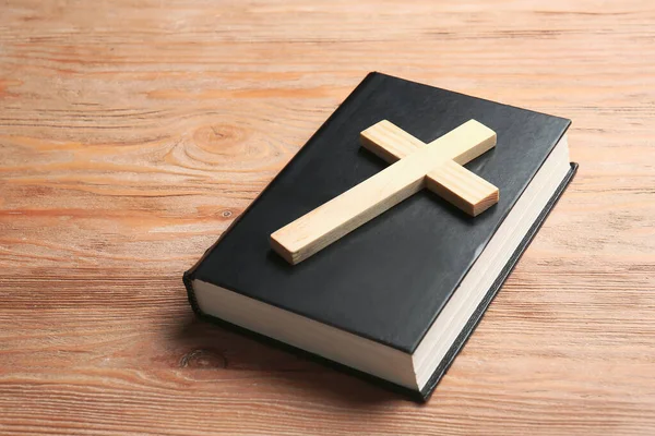 Christian cross and Bible on wooden background — Stock Photo, Image