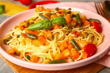 Masada lezzetli makarna ve sebze tabağı, yakın plan.