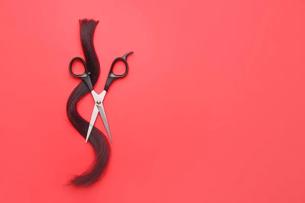 Scissors and hair strand on color background — Stock Photo, Image