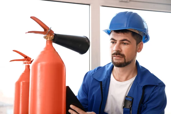 Fire safety specialist inspecting extinguisher — Stock Photo, Image