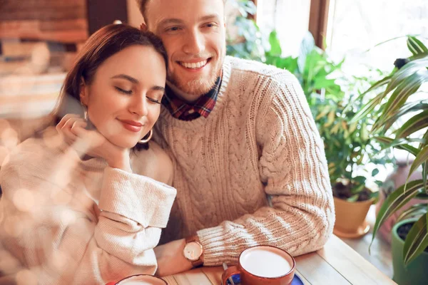 Feliz joven pareja sentada en la cafetería —  Fotos de Stock