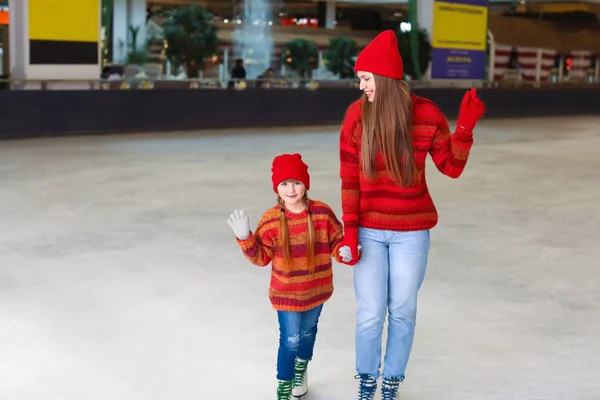 Young mother with little daughter on skating rink — Stock Photo, Image