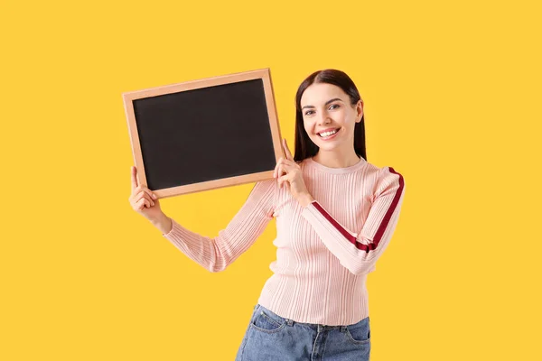Young woman with chalkboard on color background — Stock Photo, Image