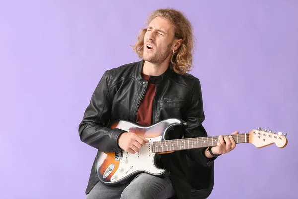 Man playing guitar and singing on color background — Stock Photo, Image
