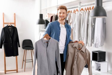 Soyunma odasında şık elbiseli yakışıklı bir adam.