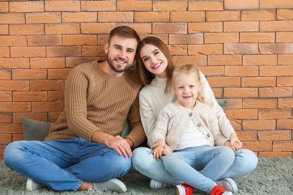 Retrato de família feliz perto da parede de tijolo — Fotografia de Stock