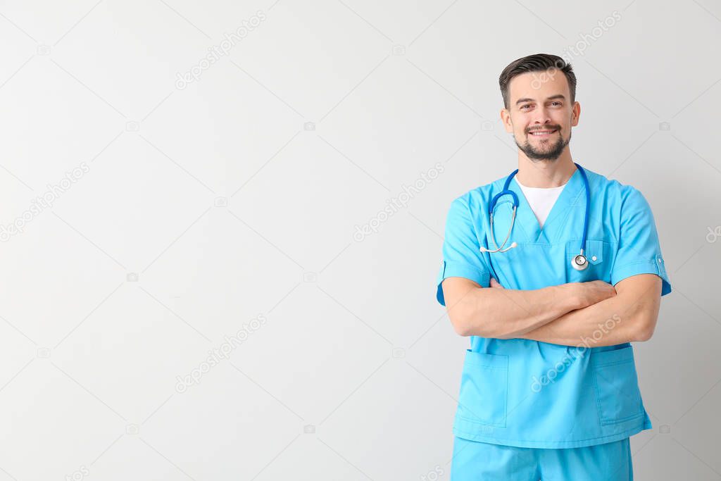 Portrait of male doctor on light background