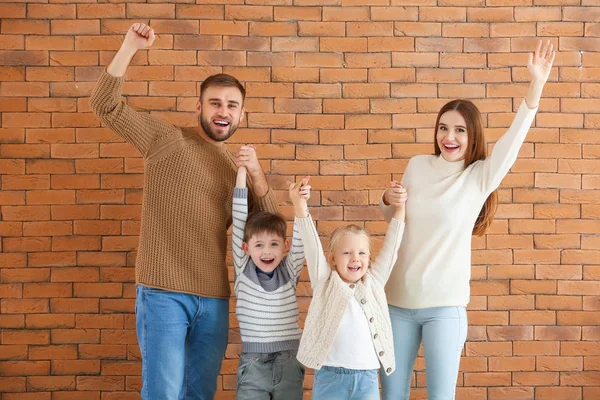 Retrato de família feliz perto da parede de tijolo — Fotografia de Stock