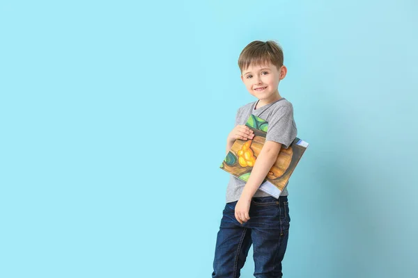 Cute little boy with book on light background — 스톡 사진