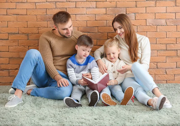 Portret van een gelukkig familie leesboek in de buurt van bakstenen muur — Stockfoto