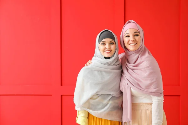 Beautiful young Muslim women on color background — 스톡 사진