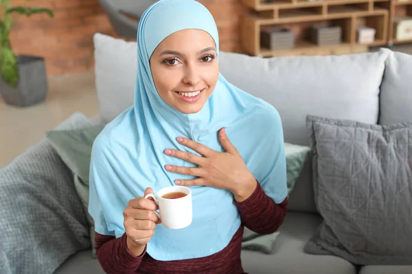 Güzel, genç Müslüman kadın evde çay içiyor. — Stok fotoğraf