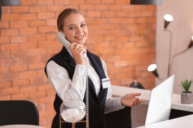 Otelin Resepsiyon, telefonla konuşurken genç kadın resepsiyonist