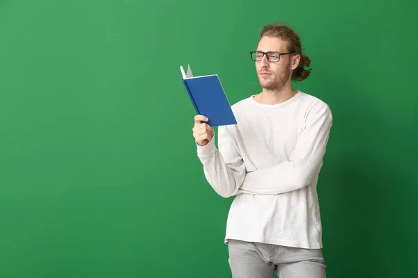 Bello uomo con libro su sfondo a colori — Foto Stock