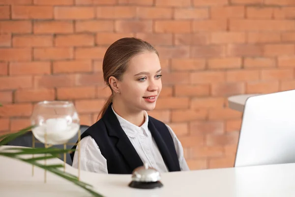 Ung kvinnlig receptionist vid skrivbordet på hotellet — Stockfoto