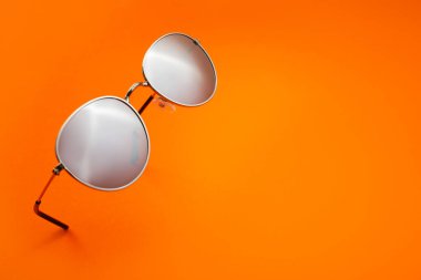 Renkli arkaplanda şık güneş gözlükleri