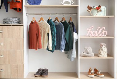 Modern wardrobe with stylish winter clothes and accessories