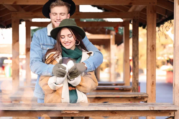 Happy young couple on Christmas fair outdoors — Stock Photo, Image