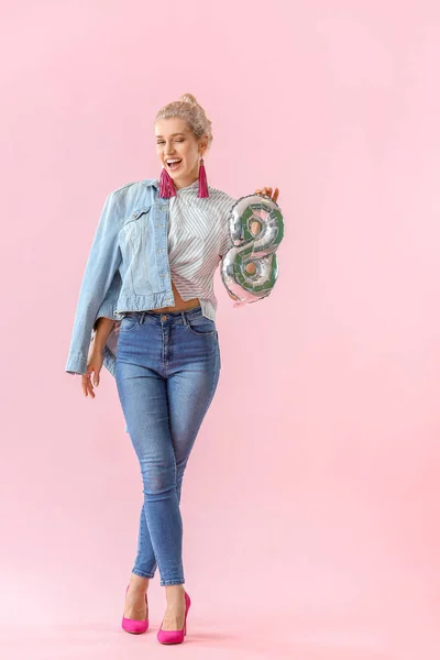 Hermosa mujer joven con globo en forma de figura 8 sobre fondo de color. Celebración del Día Internacional de la Mujer — Foto de Stock