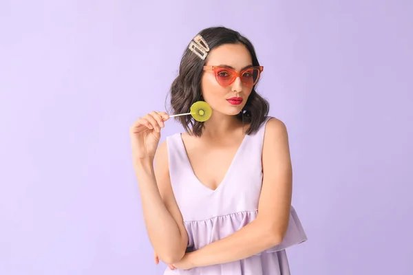 Beautiful young woman with lollipop on color background — Stock Photo, Image